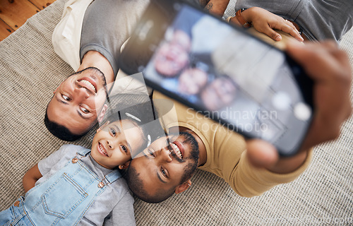 Image of Selfie, gay father and blended family with a girl lying together on the floor of the home for a picture from above. LGBT love, children or kids and a daughter with her happy parents for a photograph