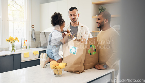 Image of Recycling, blended family or adoption with a daughter and gay couple in the home kitchen for sustainability. LGBT, eco friendly or waste with a girl and parents unpacking bananas from a grocery bag