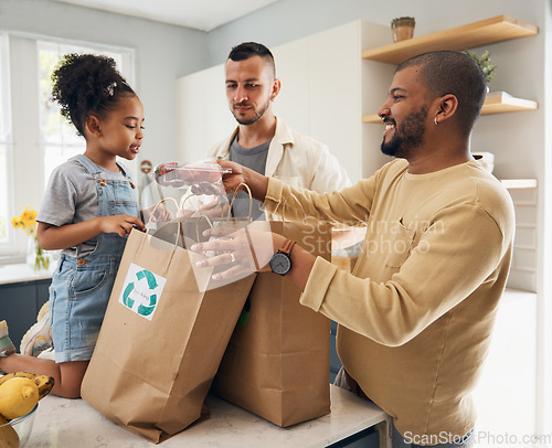 Image of Happy family, shopping and bags of groceries in home and curious, excited girl with gay parents, dad and father in kitchen. Sustainable, paper bag and kid with eco friendly grocery, product or fruit