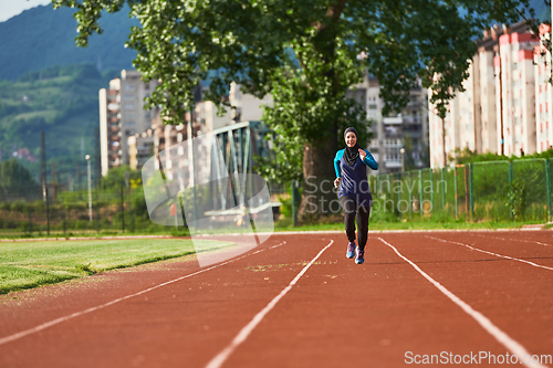 Image of A muslim woman in a burqa sports muslim clothes running on a marathon course and preparing for upcoming competitions