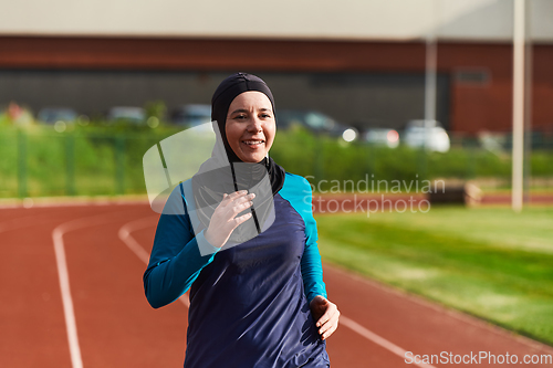 Image of A muslim woman in a burqa sports muslim clothes running on a marathon course and preparing for upcoming competitions