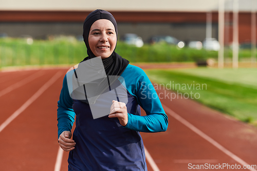 Image of A muslim woman in a burqa sports muslim clothes running on a marathon course and preparing for upcoming competitions