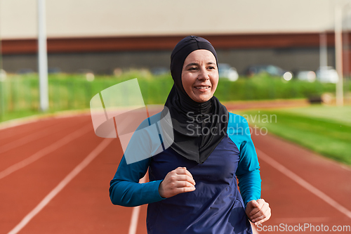 Image of A muslim woman in a burqa sports muslim clothes running on a marathon course and preparing for upcoming competitions