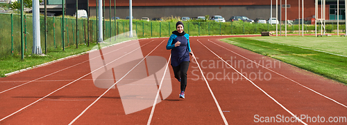 Image of A muslim woman in a burqa sports muslim clothes running on a marathon course and preparing for upcoming competitions