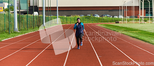 Image of A muslim woman in a burqa sports muslim clothes running on a marathon course and preparing for upcoming competitions