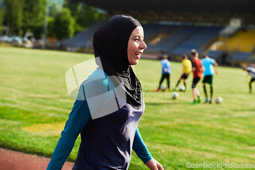 Image of A Muslim woman with a burqa, an Islamic sportswoman resting after a vigorous training session on the marathon course. A hijab woman is preparing for a marathon competition