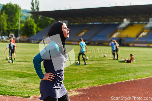 Image of A Muslim woman with a burqa, an Islamic sportswoman resting after a vigorous training session on the marathon course. A hijab woman is preparing for a marathon competition