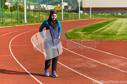 Image of A Muslim woman with a burqa, an Islamic sportswoman resting after a vigorous training session on the marathon course. A hijab woman is preparing for a marathon competition