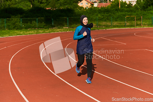 Image of A muslim woman in a burqa sports muslim clothes running on a marathon course and preparing for upcoming competitions