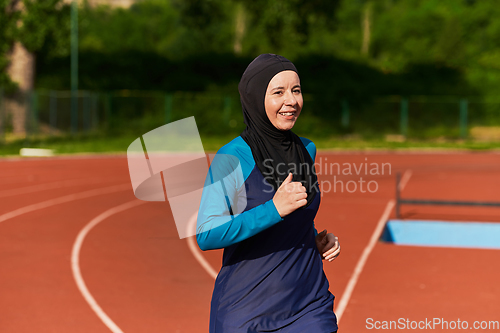 Image of A muslim woman in a burqa sports muslim clothes running on a marathon course and preparing for upcoming competitions