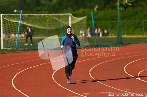 Image of A muslim woman in a burqa sports muslim clothes running on a marathon course and preparing for upcoming competitions