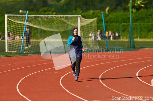 Image of A muslim woman in a burqa sports muslim clothes running on a marathon course and preparing for upcoming competitions