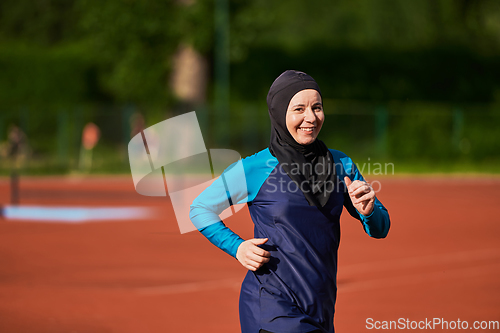 Image of A muslim woman in a burqa sports muslim clothes running on a marathon course and preparing for upcoming competitions