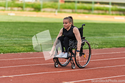 Image of A woman with disablity driving a wheelchair on a track while preparing for the Paralympic Games