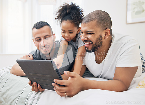 Image of Gay family, tablet and child on a bed at home for e learning, watch video and education on internet. Adoption, lgbt men or parents with a happy kid and technology for streaming movies, games or app