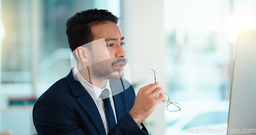 Image of Stressed web developer suffering with mental block while trying to code on a computer in his office. Frustrated data scientist struggling with fatigue and feeling the pressure to hit his deadline
