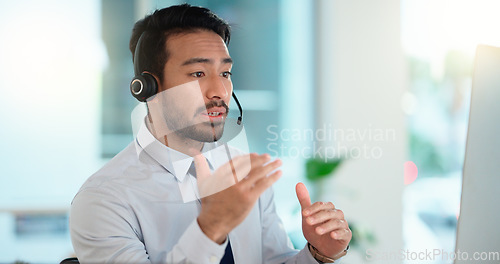 Image of Call center agent consulting a buyer via video call in an office. A young friendly sales man talking to a client in a virtual meeting. A male customer service employee advising a consumer