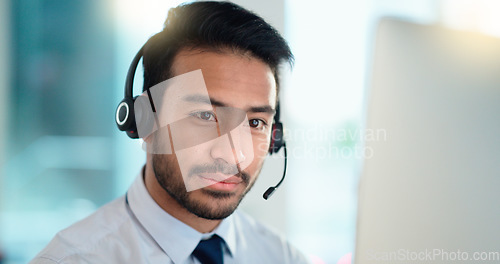 Image of Call center agent talking and listening to a client on a headset while working in an office. Confident and reassuring salesman consulting and operating a helpdesk for customer service and support