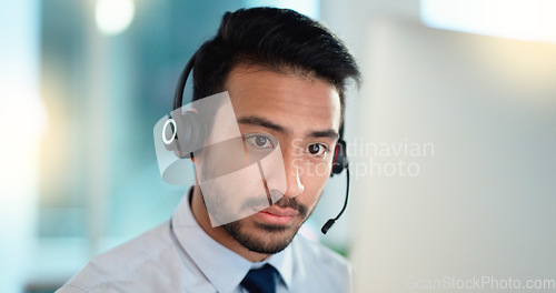 Image of Call center agent talking and listening to a client on a headset while working in an office. Confident and reassuring salesman consulting and operating a helpdesk for customer service and support