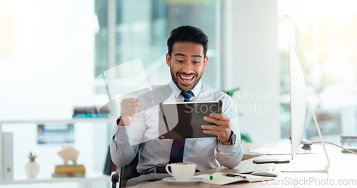 Image of Successful and excited business man cheering with joy while working on digital tablet in an office. Happy trader and banker celebrating victory after reading good news about an exciting deal or bonus