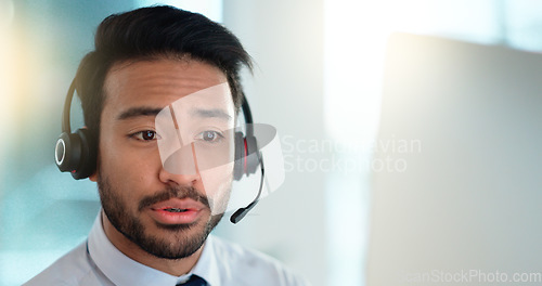 Image of Call centre agent wearing headset giving great customer support service via email at his desk. Confident young sales representative making a sale at his helpdesk in the office. Operator sends invoice