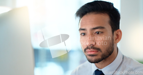 Image of Business man reading his emails and browsing online on a desktop computer while working in an office at work. One male corporate worker while networking and connecting with clients on the internet