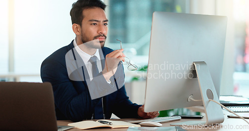 Image of Business man analyzing a project strategy on a computer screen while working in an office. Serious and focused corporate professional thinking of solutions while considering ideas, choices and plans