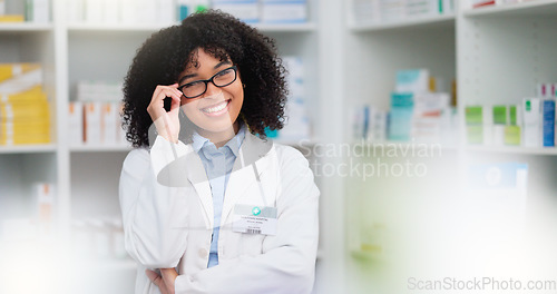 Image of A friendly female pharmacist with a bright smile is about to help patients at the dispensary. Portrait of happy woman healthcare professional smiling at the pharmacy. A doctor taking off her glasses