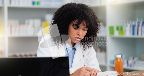 Image of Young and focused pharmacist use her computer to do stock taking and dispense medicine in a pharmacy or drugstore. Female health professional or chemist filling out prescription medication documents