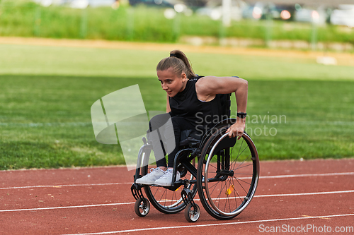 Image of A woman with disablity driving a wheelchair on a track while preparing for the Paralympic Games