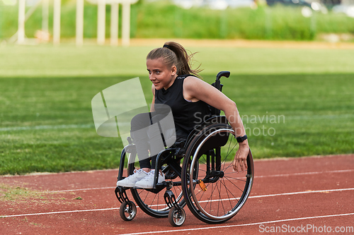 Image of A woman with disablity driving a wheelchair on a track while preparing for the Paralympic Games