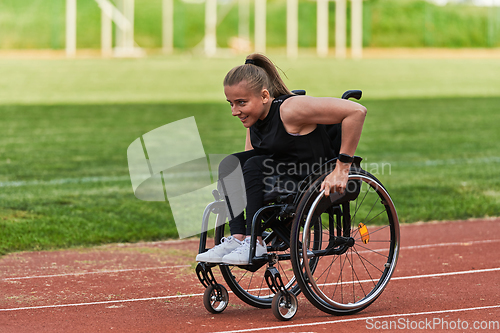 Image of A woman with disablity driving a wheelchair on a track while preparing for the Paralympic Games