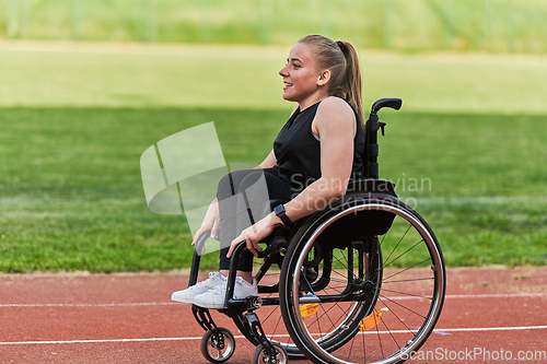 Image of A woman with disablity driving a wheelchair on a track while preparing for the Paralympic Games