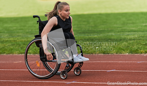 Image of A woman with disablity driving a wheelchair on a track while preparing for the Paralympic Games