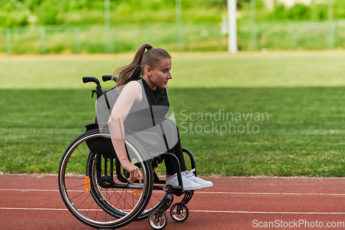 Image of A woman with disablity driving a wheelchair on a track while preparing for the Paralympic Games