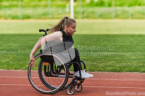 Image of A woman with disablity driving a wheelchair on a track while preparing for the Paralympic Games