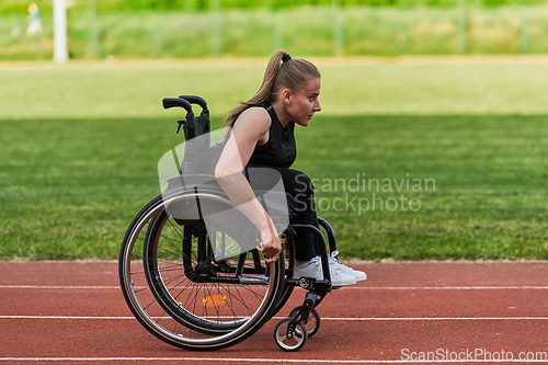 Image of A woman with disablity driving a wheelchair on a track while preparing for the Paralympic Games