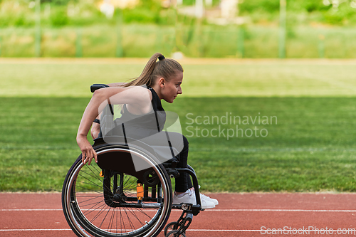 Image of A woman with disablity driving a wheelchair on a track while preparing for the Paralympic Games