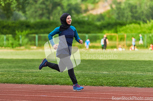 Image of A muslim woman in a burqa sports muslim clothes running on a marathon course and preparing for upcoming competitions