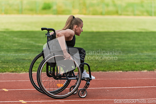 Image of A woman with disablity driving a wheelchair on a track while preparing for the Paralympic Games