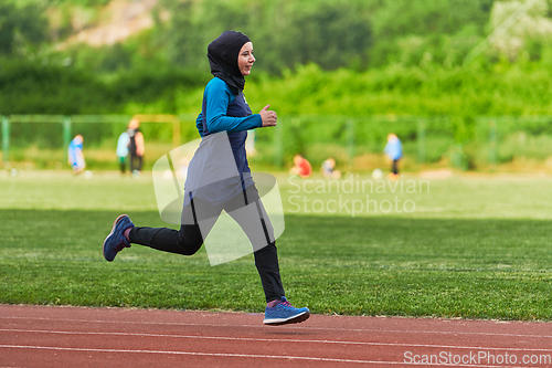 Image of A muslim woman in a burqa sports muslim clothes running on a marathon course and preparing for upcoming competitions