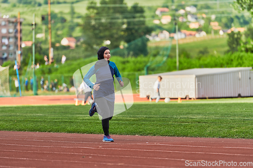 Image of A muslim woman in a burqa sports muslim clothes running on a marathon course and preparing for upcoming competitions