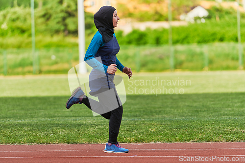 Image of A muslim woman in a burqa sports muslim clothes running on a marathon course and preparing for upcoming competitions