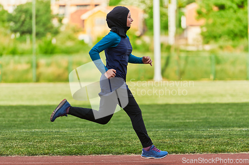 Image of A muslim woman in a burqa sports muslim clothes running on a marathon course and preparing for upcoming competitions