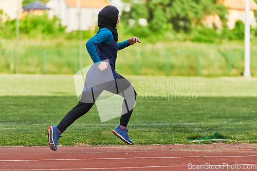 Image of A muslim woman in a burqa sports muslim clothes running on a marathon course and preparing for upcoming competitions