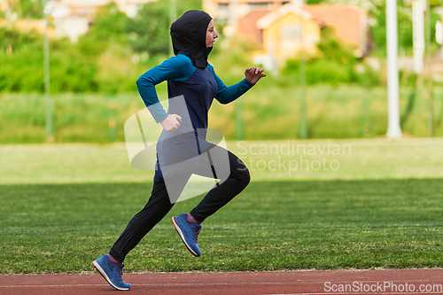 Image of A muslim woman in a burqa sports muslim clothes running on a marathon course and preparing for upcoming competitions