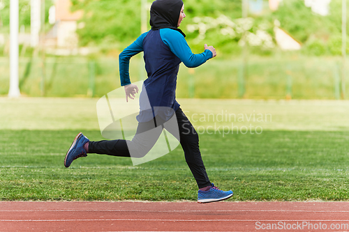 Image of A muslim woman in a burqa sports muslim clothes running on a marathon course and preparing for upcoming competitions