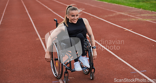 Image of A woman with disablity driving a wheelchair on a track while preparing for the Paralympic Games