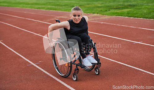 Image of A woman with disablity driving a wheelchair on a track while preparing for the Paralympic Games