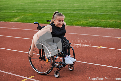 Image of A woman with disablity driving a wheelchair on a track while preparing for the Paralympic Games